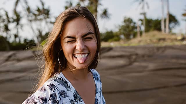A woman is smiling and showing a tongue