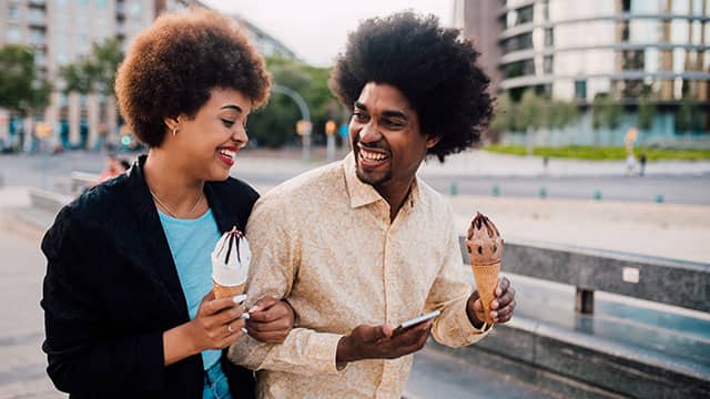 A young couple eating an ice cream on the street