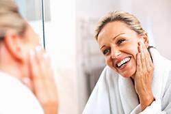 Happy mature woman smiling in the mirror