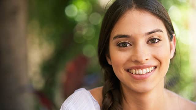 A woman smiling outside