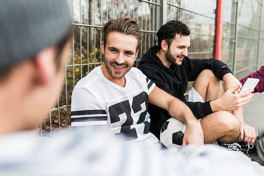 Young men talking after playing soccer