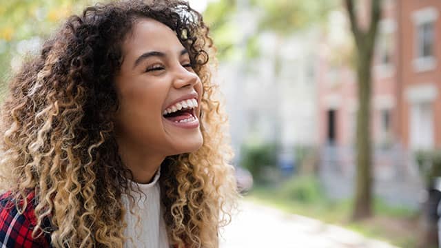 Happy young woman is smiling on the street