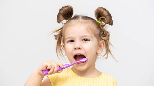 Niña lavándose los dientes