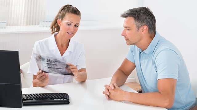 Dentist and patient looking at an X-ray in an office