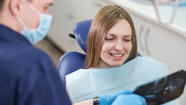 A girl patient and male dentist watching an x-ray