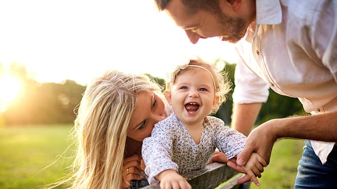 family playing with baby outside
