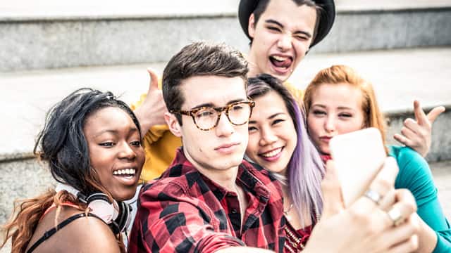 A group of teens taking a selfie on some steps outdoors