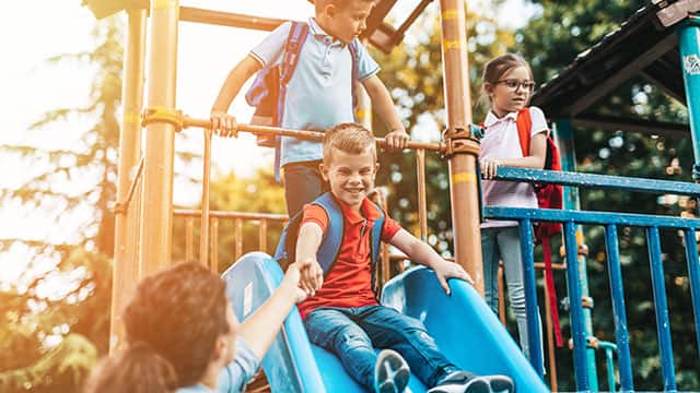 School children playing on the slide