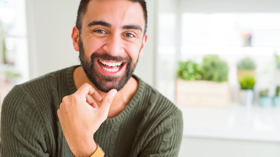 Man wearing a straw hat smiling with white teeth