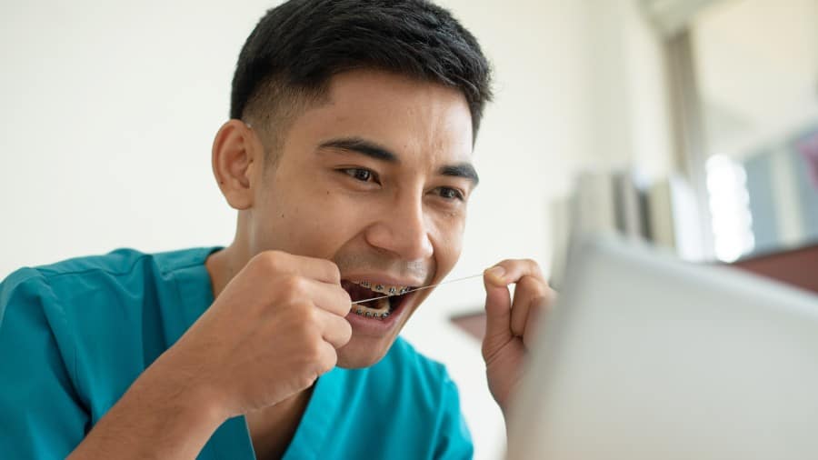 cleaning between teeth with a floss threader - colgate philippines