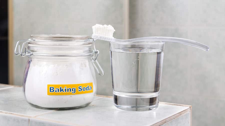 Baking soda, a toothbrush, and a glass of water
