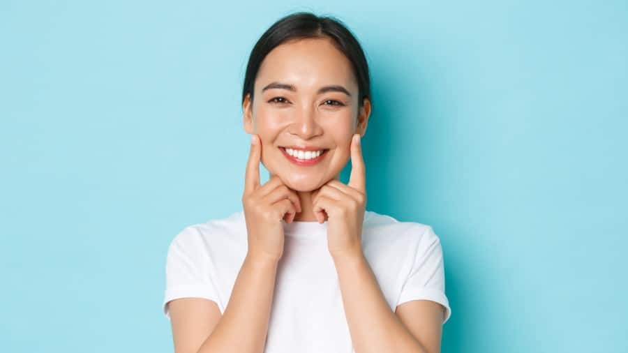 Woman smiling with bright white teeth after using teeth whitening serum