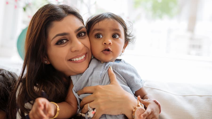 Mom pampering her baby, who is about to have baby first tooth