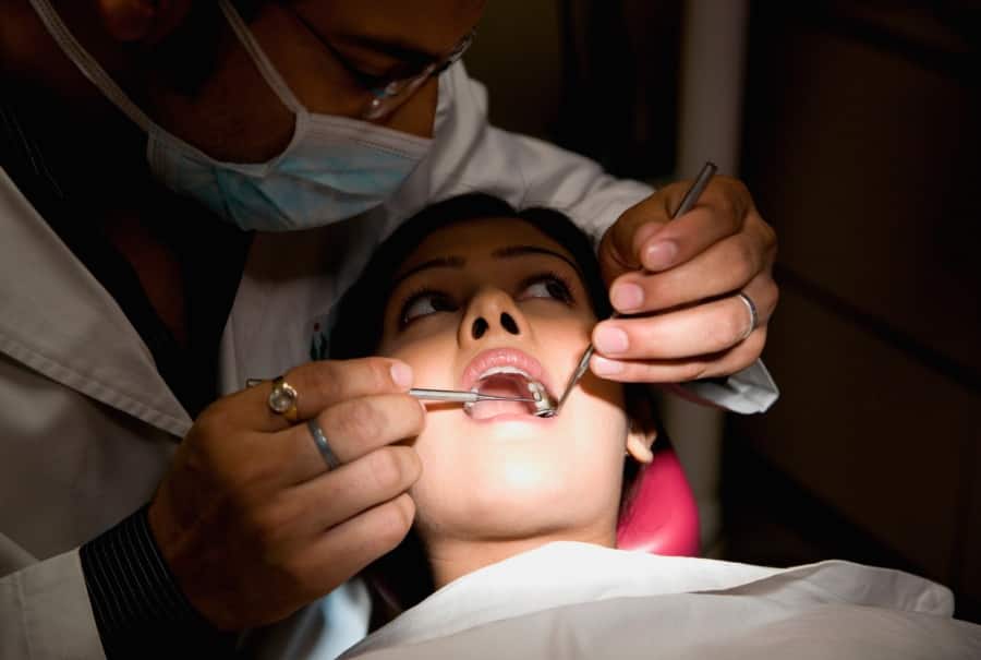A young woman is getting medical assistance for swollen gums.