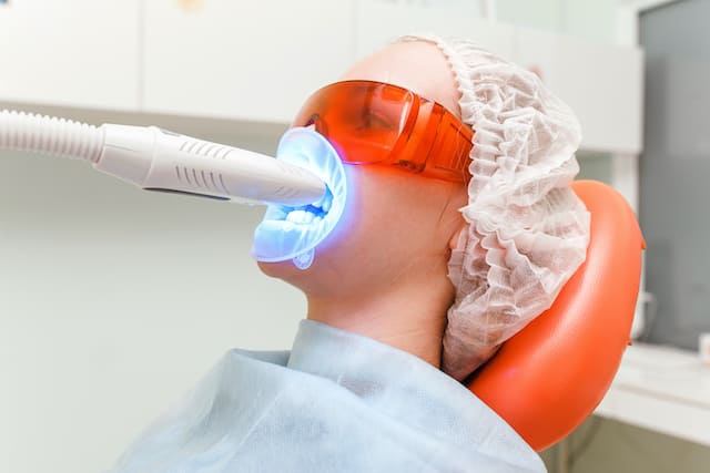 A patient receiving a LED teeth whitening treatment