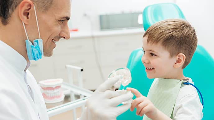 Odontologo juega con niño en el consultorio