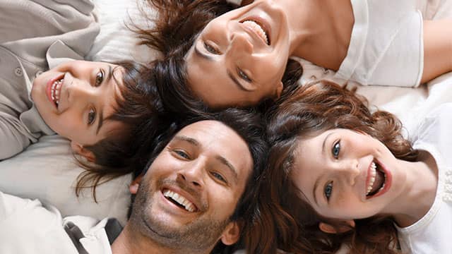 Kameraya gülümseyen 4 mutlu aile