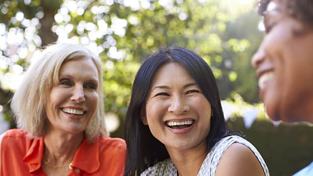 Mature Female Friends Socializing In Backyard Together