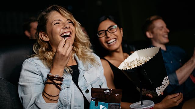 Young woman with friends watching movie