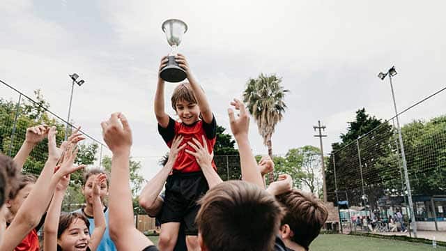Kids celebrating a soccer win with their coach