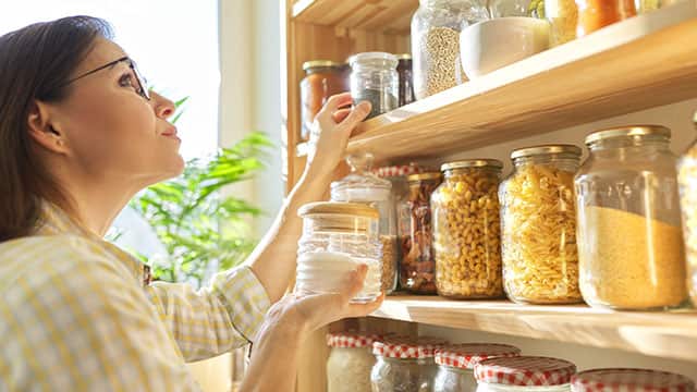 A woman holding jar of salt in a hand