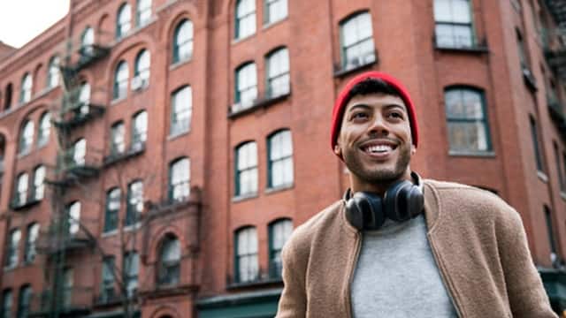 Low angle view of young man standing on city street