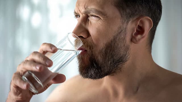 Male rinsing tooth with water