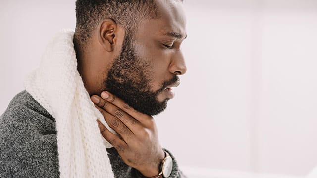 Man with a sore throat in pain
