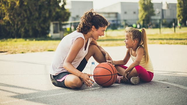 Mother and daughter sitting together after a basketball game