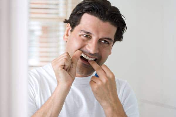 Hombre con hilo dental