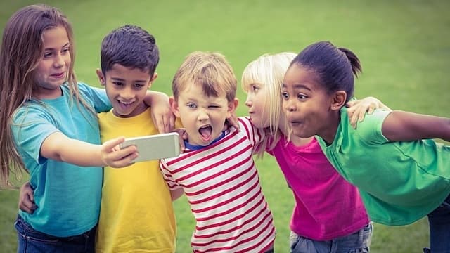 Smiling classmates posing funny and taking selfies 
