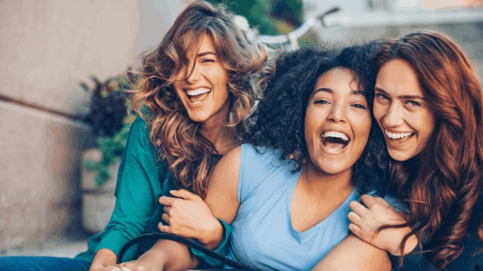 Three girlfriends laughing together