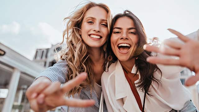 Two young women smiling outdoors