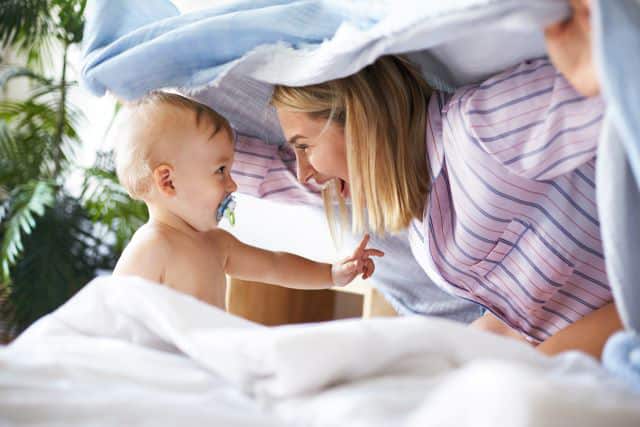 Bebé con chupeta jugando con su mamá