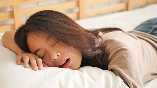 Young woman is sleeping with the open mouth