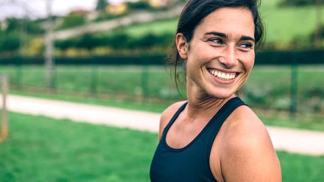 A woman is smiling outside