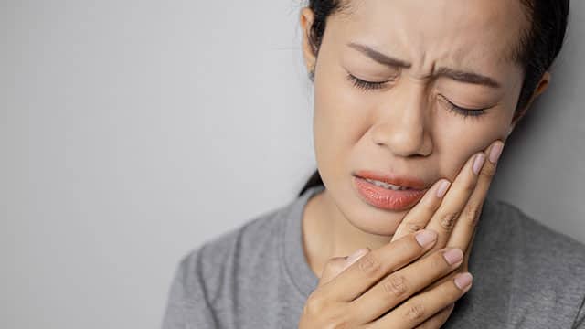 Woman in pain holding her cheek