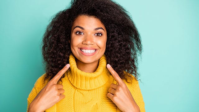 Woman pointing at her big smile