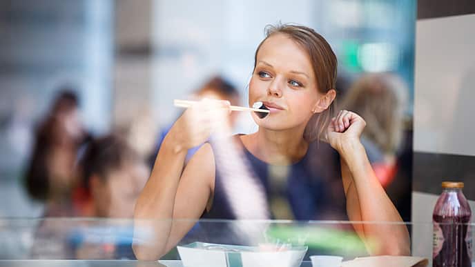 woman eating sushi alone