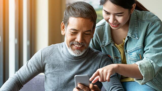 daughter showing dad something on his phone
