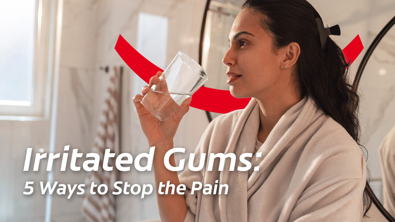 Woman in a bathrobe holding a glass of water with text reading Irritated Gums: 5 Ways to Stop the Pain.