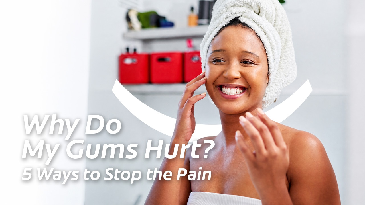 Smiling woman with a hair towel touching her face with text reading Why Do My Gums Hurt? 5 Ways to Stop the Pain.