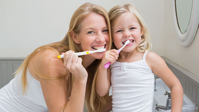 Mother and daughter brushing their tooth