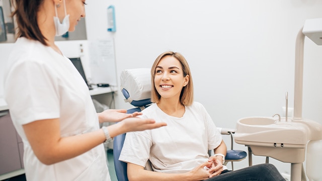 Young woman talking to dentist