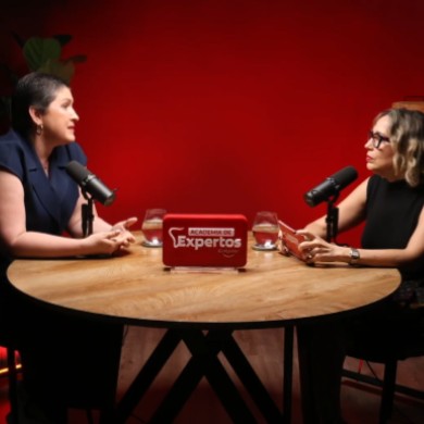 Más allá de la edad: claves odontológicas para adultos mayores. Dos panelistas conversando en podcast Academia de Expertos Colgate con micrófonos en estudio de fondo rojo.