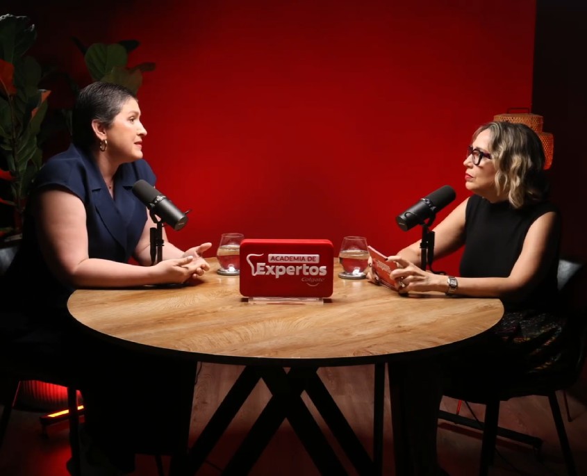 Más allá de la edad: claves odontológicas para adultos mayores. Dos panelistas conversando en podcast Academia de Expertos Colgate con micrófonos en estudio de fondo rojo.