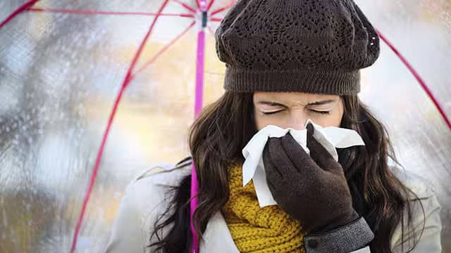 Femme éternuant en extérieur