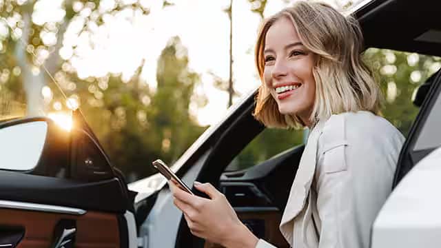 A woman sitting in car and using cellphone