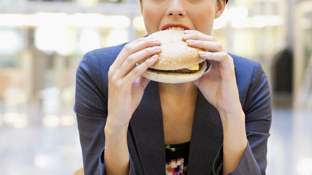 Mujer comiendo una hamburguesa
