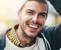 A man is smiling outside